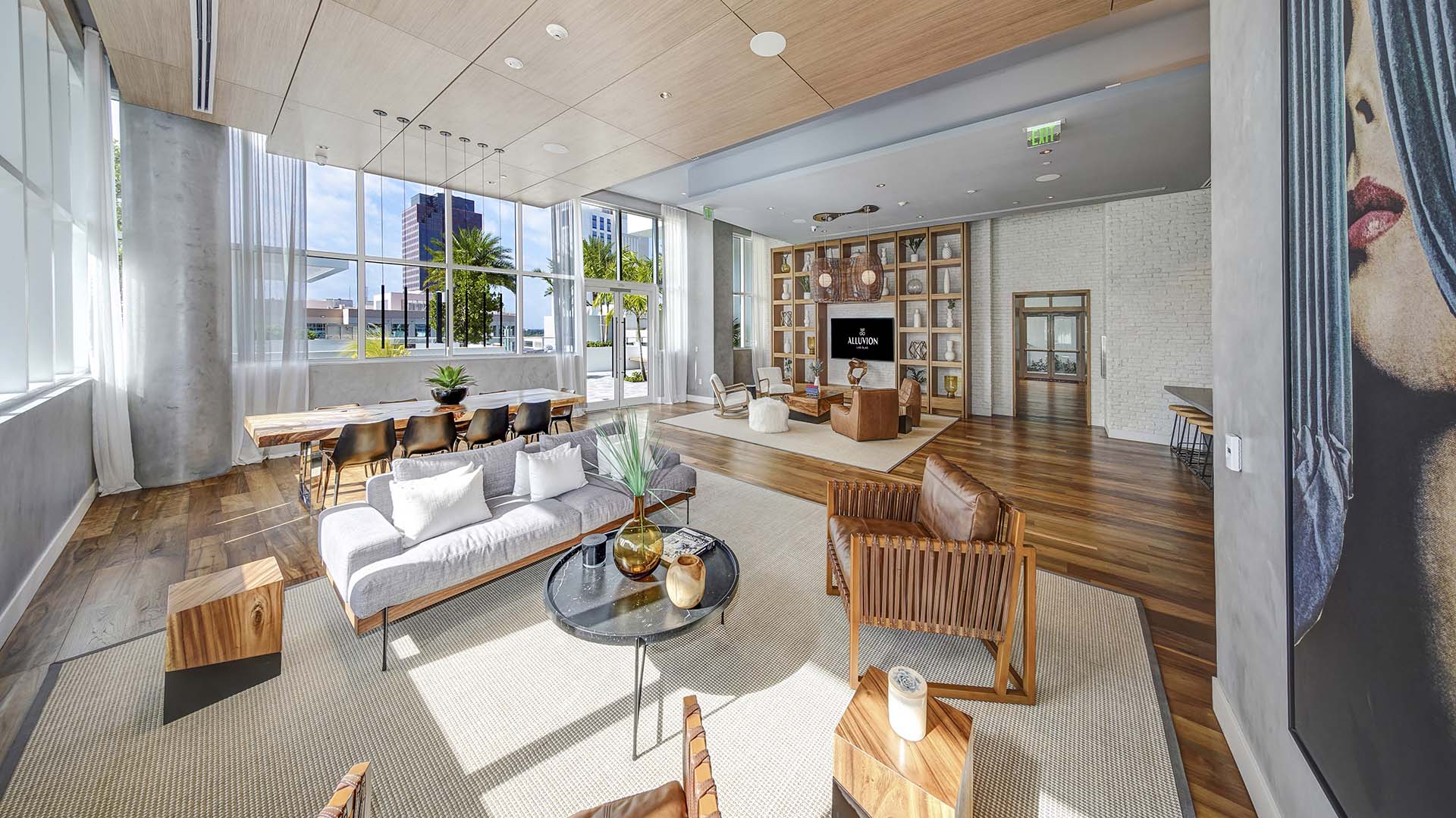 Lounge with plush seating, shelves with decor, TV, and wall mural.