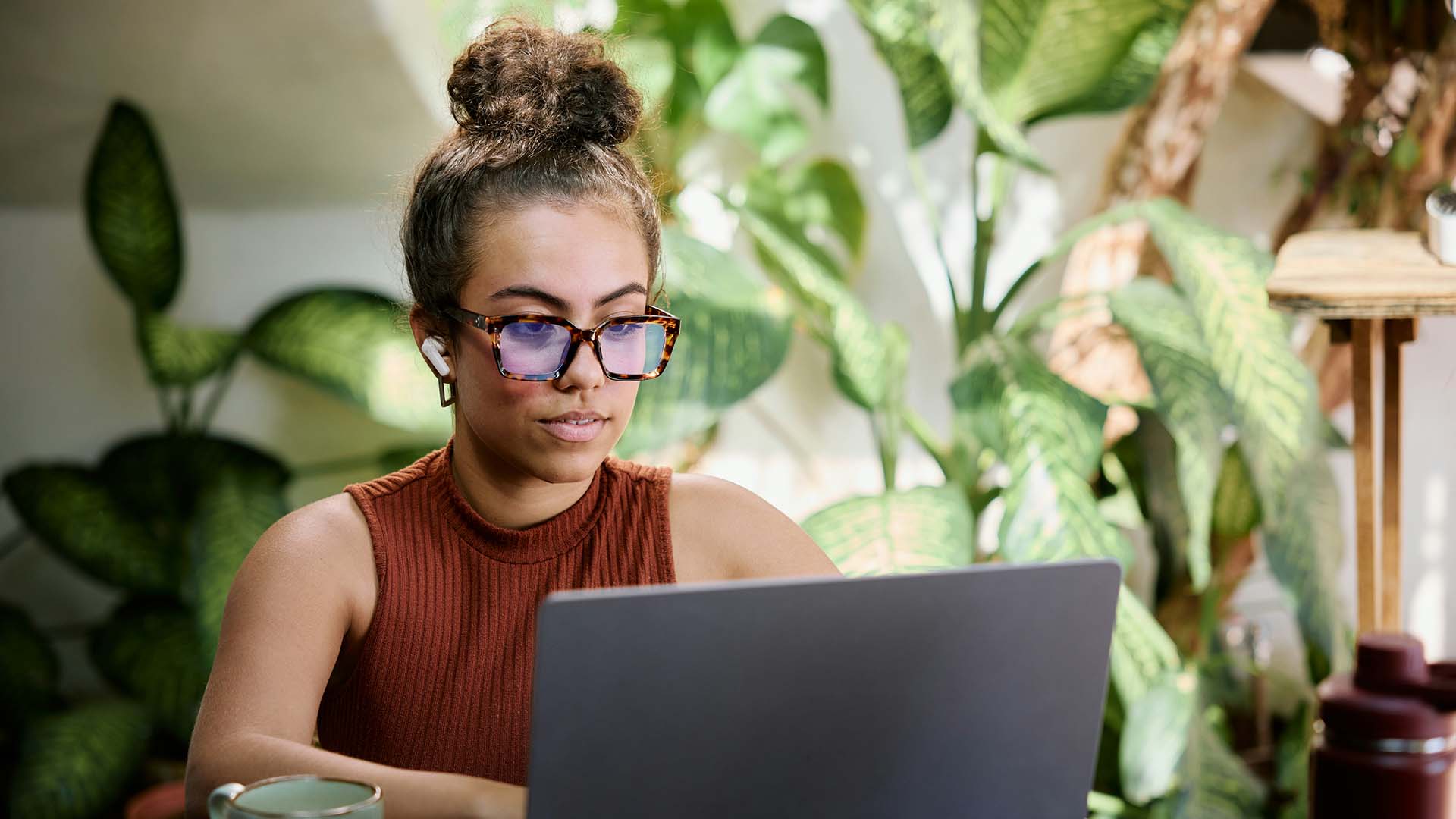 Person with glasses working on laptop computer.