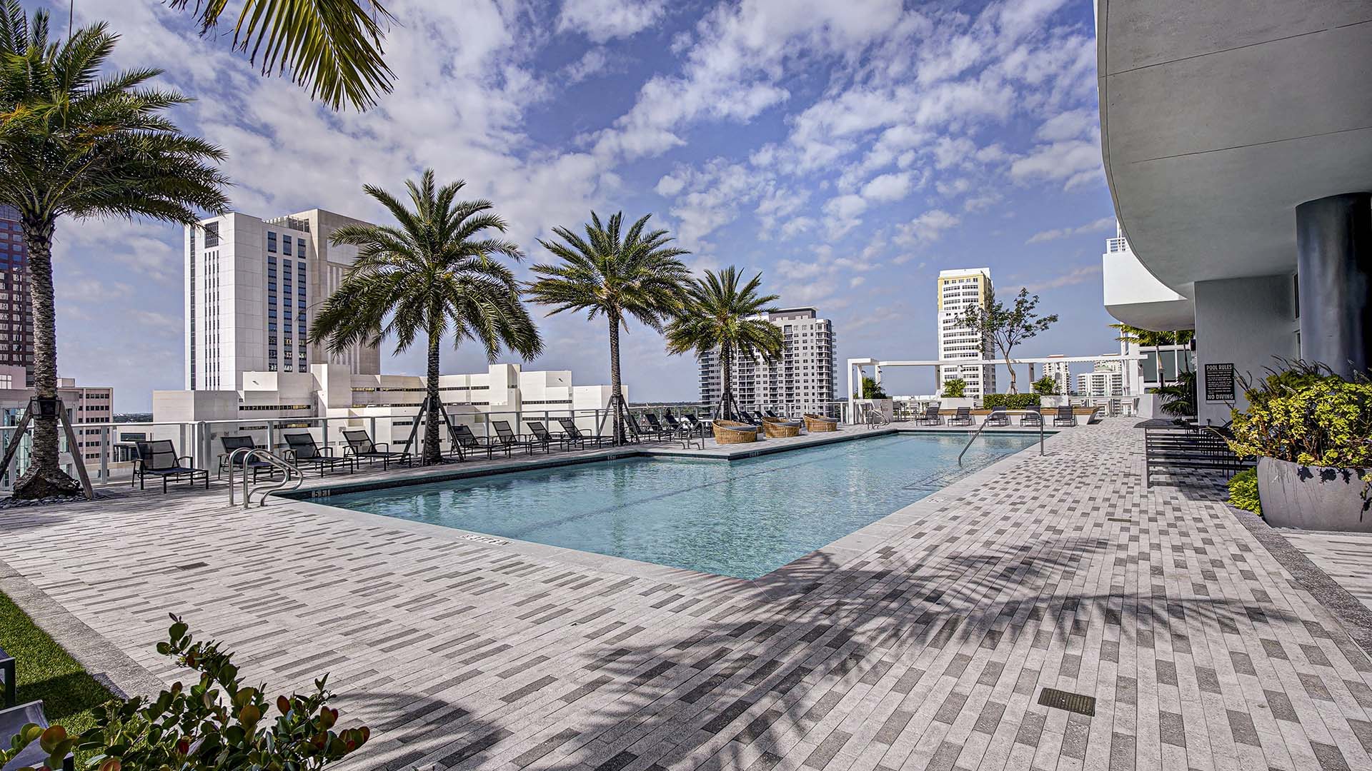 Alluvion rooftop pool under cloudy skies.